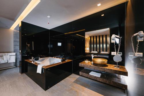 Baño negro con bañera y lavamanos en Hotel Egnatia, en Tirana