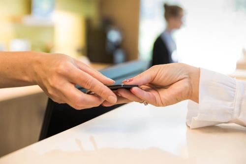 a person holding a cell phone in their hands at Kubija Hotel and NatureSpa in Võru