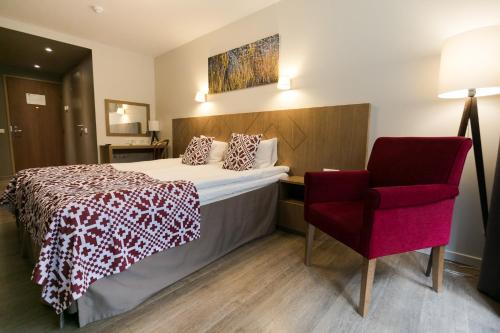 a hotel room with a bed and a red chair at Kubija Hotel and NatureSpa in Võru