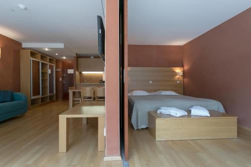 a bedroom with a bed and a living room at Kubija Hotel and NatureSpa in Võru