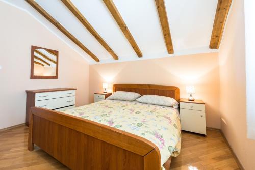ein Schlafzimmer mit einem Bett und zwei Nachttischen in der Unterkunft Apartments Villa Kulish in Cavtat