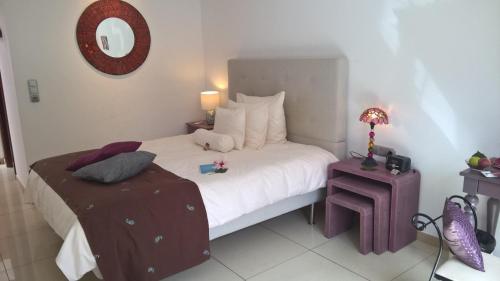 a bedroom with a bed and a table with a lamp at Birdcage Gay Men Resort and Lifestyle Hotel in Playa del Ingles