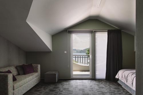 a living room with a couch and a large window at Romantique Veles Hotel in Veles