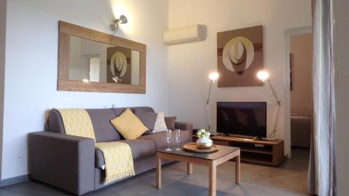 a living room with a couch and a tv at Résidence les Hameaux de Bocca del Oro in Porto-Vecchio