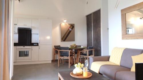a living room with a couch and a table at Résidence les Hameaux de Bocca del Oro in Porto-Vecchio