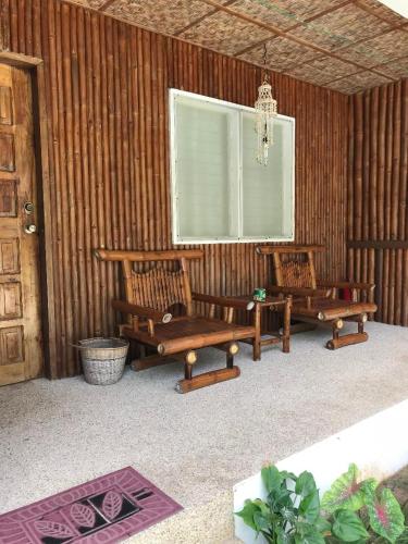 two benches sitting in a room with a window at Charisma Beach Resort in Siquijor