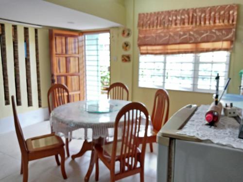 a dining room with a table and chairs and a kitchen at Jazepuri - Jaze 1 in Kuching