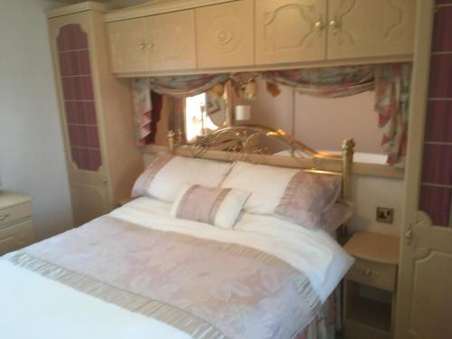 a bedroom with a large bed with a window at Golden palm resort skegness in Chapel Saint Leonards