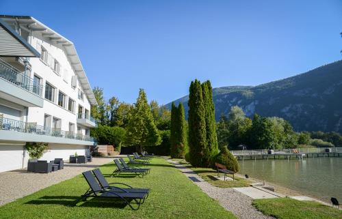 a row of chairs sitting on the grass next to a building at Novalaise Plage in Novalaise