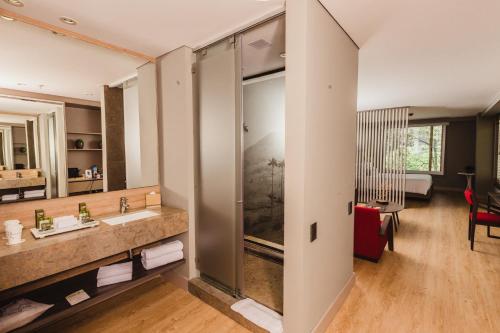 a bathroom with a sink and a large mirror at Hotel Habitel Prime in Bogotá