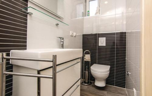 La salle de bains est pourvue d'un lavabo blanc et de toilettes. dans l'établissement Apartments Jankovic, à Biograd na Moru