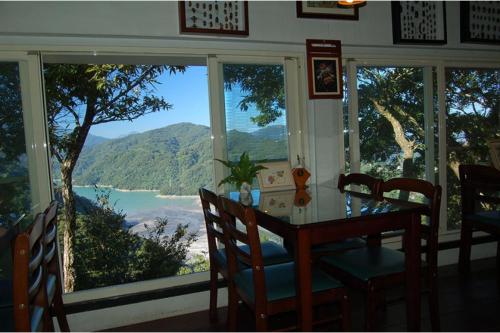 a dining room with a table and a view of the ocean at Shan Ju Lake Villa in Renai
