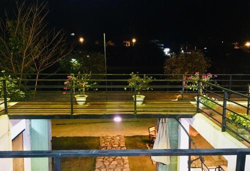 a balcony with potted plants on it at night at Bac Ha Boutique Homestay in Bắc Hà