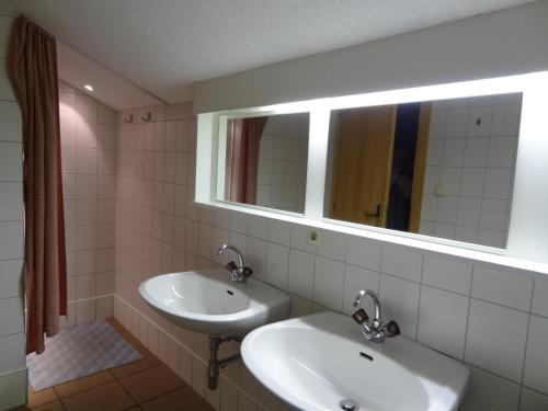 a bathroom with two sinks and a mirror at Haus Eberhard in Vent