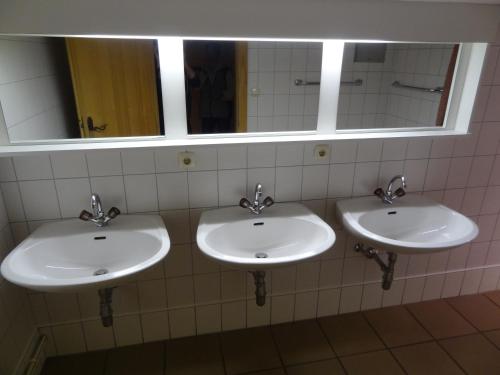 a bathroom with three sinks and a mirror at Haus Eberhard in Vent