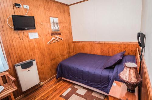 1 dormitorio con cama y pantalla de proyección en Hostal Chalet Las Violetas, en Punta Arenas