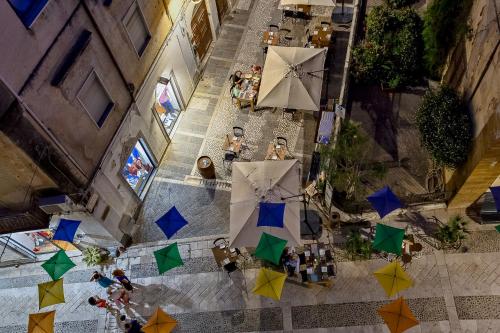 an overhead view of a street with tables and umbrellas at Cantine De Gregorio Suites in Sciacca