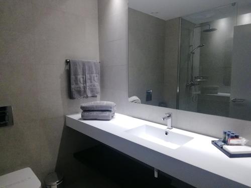 a bathroom with a sink and a mirror at Hg City Suites Barcelona Apartments in Barcelona