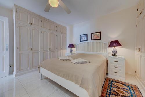 1 dormitorio con 1 cama grande y armarios blancos en Exclusive frontline one bedroom apartment, en Puerto de Santiago