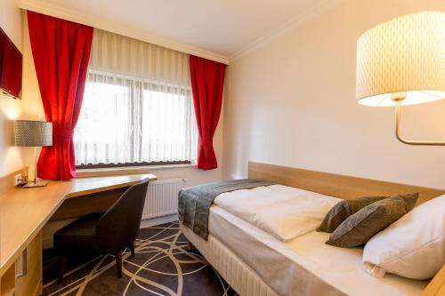 a hotel room with a bed and a desk and a desk at Hotel Lang in Breidenbach