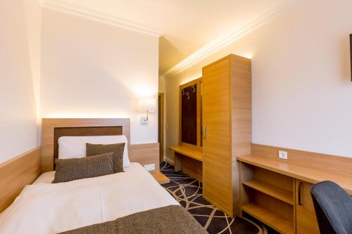 a hotel room with a bed and a desk at Hotel Lang in Breidenbach