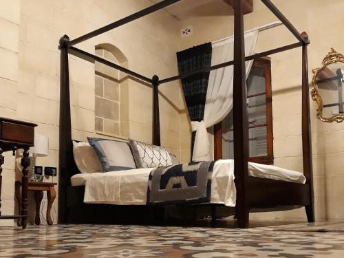 a bedroom with a canopy bed in a room at The 3Cities Auberge in Cospicua