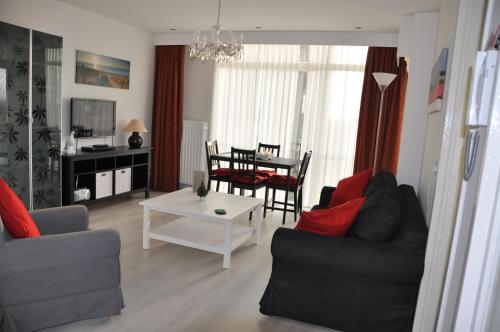 ein Wohnzimmer mit einem Sofa und einem Tisch in der Unterkunft Schelvis Apartments in Zandvoort