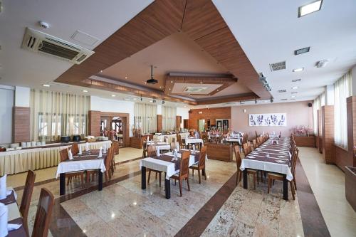 um restaurante com mesas e cadeiras num quarto em Hotel Slovenj Gradec em Slovenj Gradec