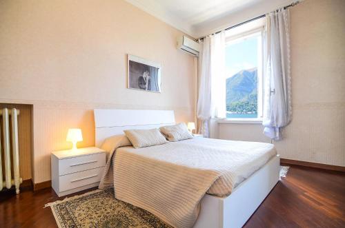 een slaapkamer met een groot bed en een raam bij Appartamenti Il Sogno in Bellagio