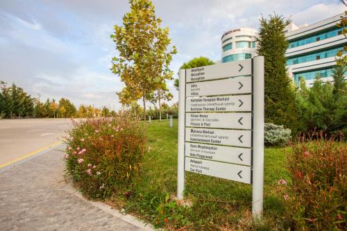 a sign in the grass next to a street at Gashalti Health Hotel Naftalan in Naftalan