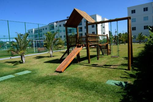 a playground in a park with a swing at Palm Village Acqua in Porto De Galinhas