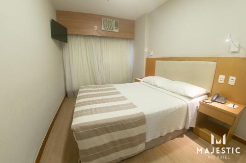 a hotel room with a bed and a window at Majestic Rio Palace Hotel in Rio de Janeiro