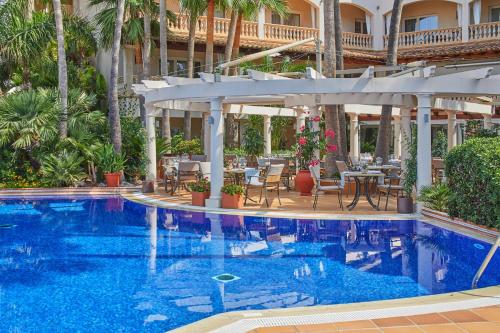 una piscina con patio y un hotel en Boutiquehotel El Coto, en Colonia de Sant Jordi