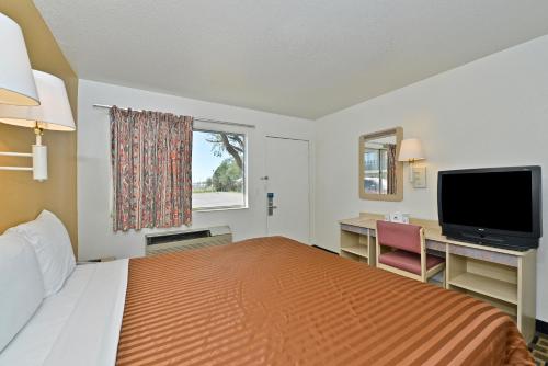 a bedroom with a bed and a desk and a television at Americas Best Value Inn Amarillo Airport/Grand Street in Amarillo