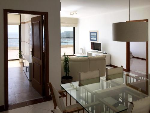 a living room with a glass table and a couch at Sea View Apartment Sesimbra- Apartamento Vista Mar in Sesimbra