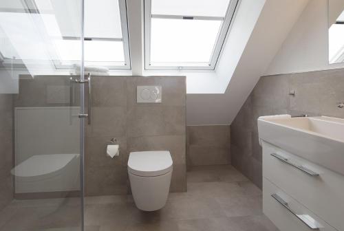 a bathroom with a toilet and a sink and a window at MeerBlickD21 Residenzen in Norderney