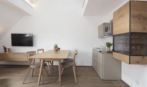 a kitchen with a wooden table and chairs in a room at MeerBlickD21 Residenzen in Norderney