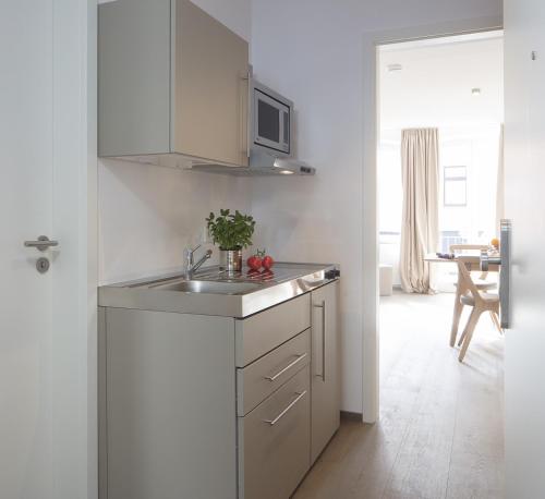 a kitchen with a sink and a microwave at MeerBlickD21 Residenzen in Norderney