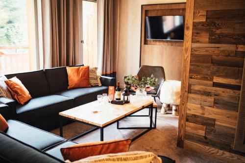 a living room with a couch and a table at Hôtel L'Arboisie in Megève