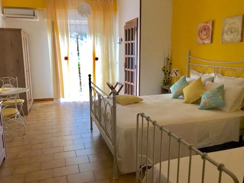a bedroom with a large bed with yellow walls at Casa Del Sole B&B in Tropea