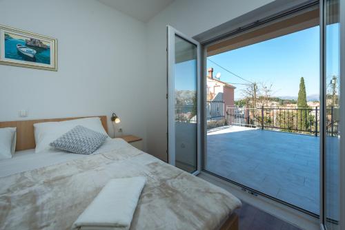a bedroom with a bed and a large glass window at Apartments Rilovic, City and Sea view apartments in Cavtat