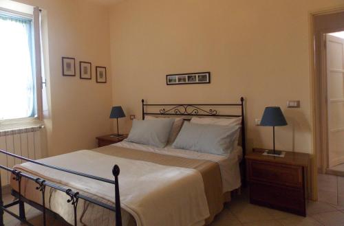 a bedroom with a bed and two lamps and a window at La Casetta in Piazza in Pincara
