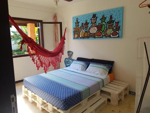 1 dormitorio con 1 cama y una pintura en la pared en Loft-Atelier 100m praia, en Florianópolis