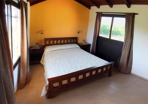 een slaapkamer met een groot bed en een raam bij CABAÑAS AGUARI in Santa Rosa de Calamuchita