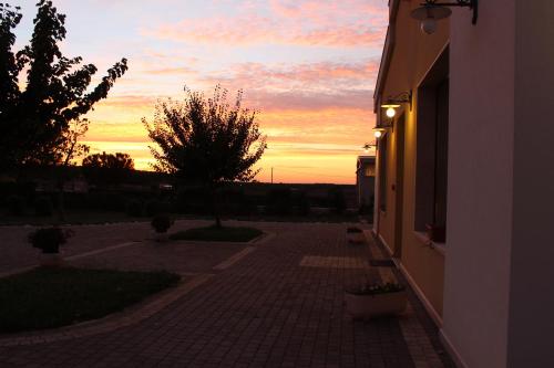 a sunset over a brick walkway with a building at Masseria Chinunno in Altamura