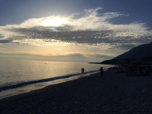 a group of people walking on the beach at Sea View Hotel Dhermi in Dhërmi