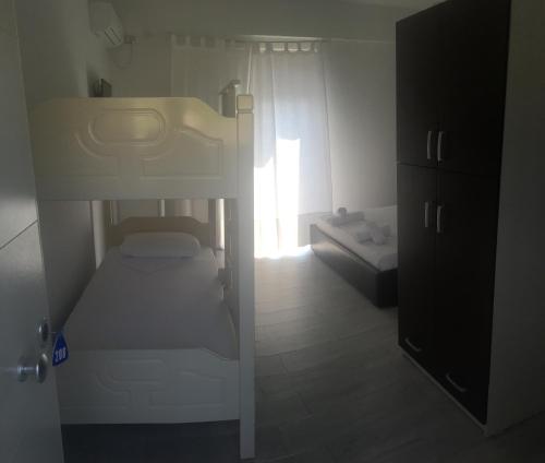 a small bedroom with a bunk bed and a window at Sea View Hotel Dhermi in Dhërmi