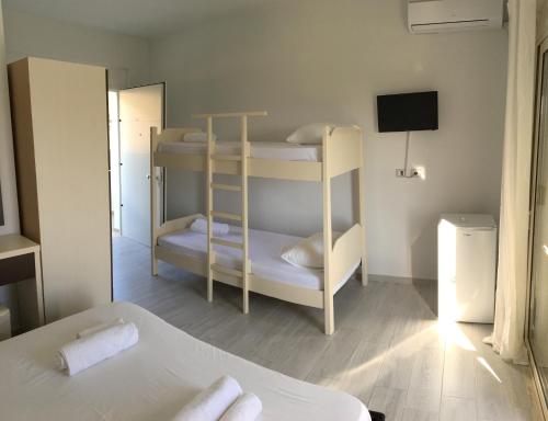 a room with two bunk beds and a television at Sea View Hotel Dhermi in Dhërmi
