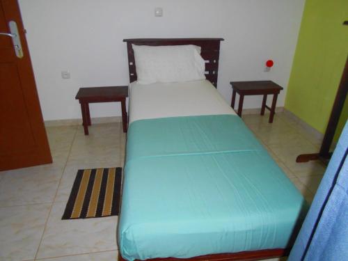 een klein bed in een kamer met een groene matras bij Guest House Frontera in Pinto