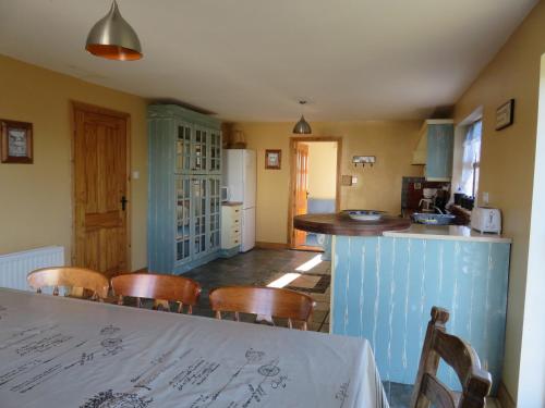 uma cozinha com mesa e cadeiras num quarto em Letterfrack Mountain Farm Cottage on farm in village centre em Letterfrack